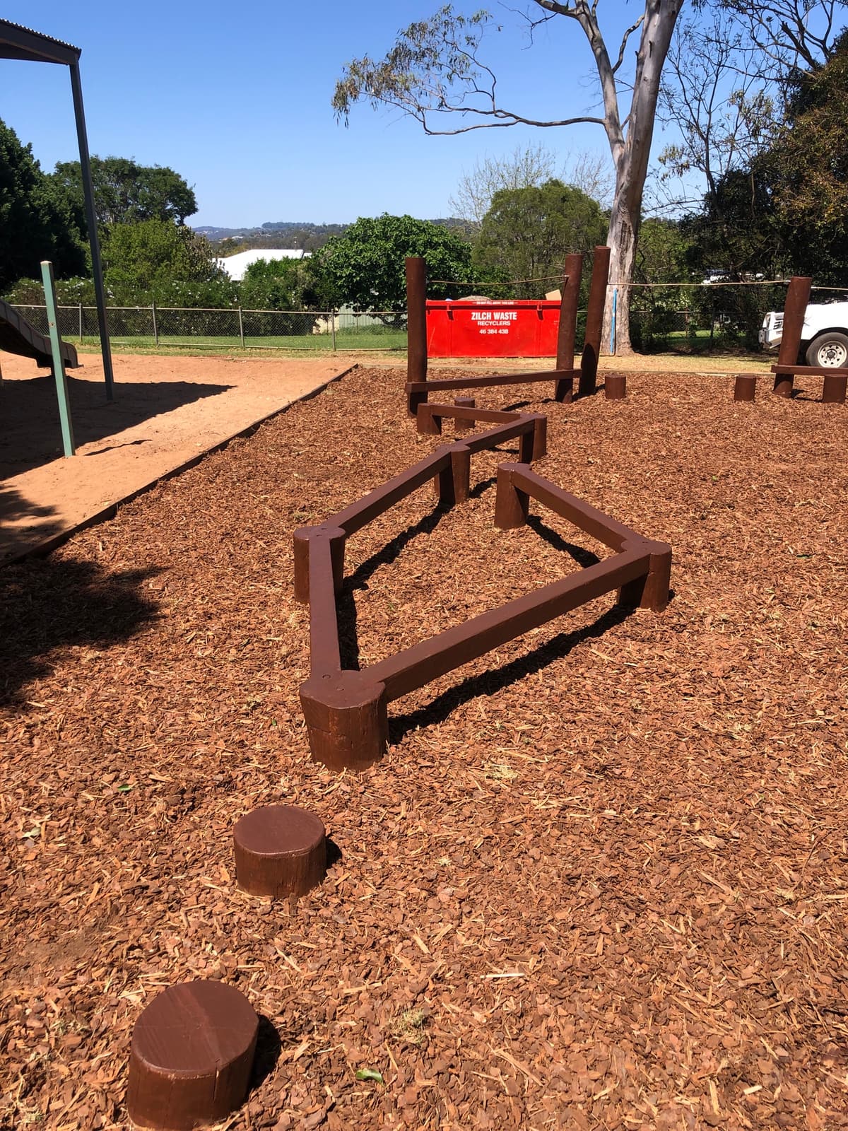 Low timber balance-beam circuit and log steppers laid out over bark mulch in Highfields